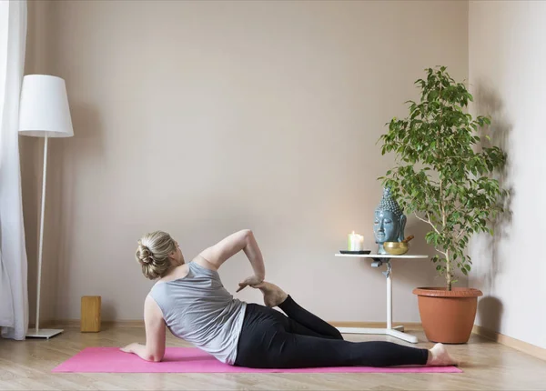 Kobieta w średnim wieku uprawia jogę w domu — Zdjęcie stockowe