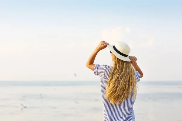 Kvinna på stranden bär vit hatt — Stockfoto