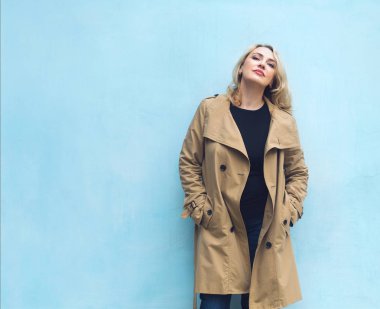 Orta yaş kadın mavi duvarının yakınında. Mutluluk kavramı.