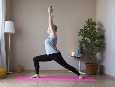 Orta yaşlı kadın evde yoga yapıyor.