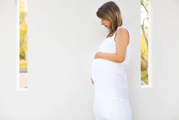 Mulher grávida tocando sua barriga com as mãos — Fotografia de Stock