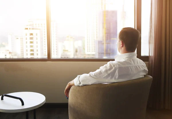 Rear view of man relaxing on chair in the room — Stock Photo, Image