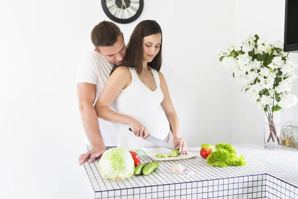 Jovem e mulher grávida bonita cozinhar na cozinha — Fotografia de Stock