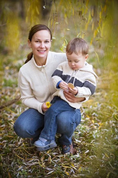 Ung mamma med son i höst park — Stockfoto