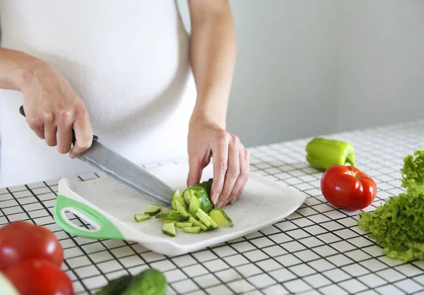 Jovem mulher grávida cozinhar salada de legumes na cozinha — Fotografia de Stock