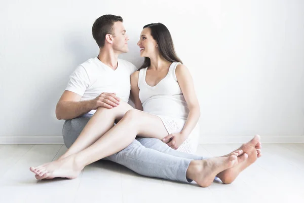 Young man and pretty pregnant woman hugging together — Stock Photo, Image