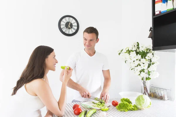 Young man and pretty pregnant woman cooking at kitchen — Stock Photo, Image