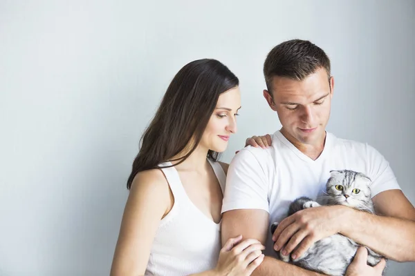 Jeune homme avec femme enceinte et chat à l'intérieur — Photo