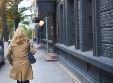 Orta yaş kadın şehir ve gülümsüyor gider. Yalnızlık co