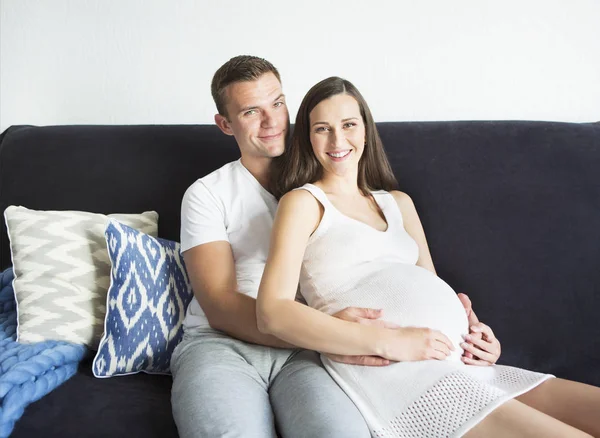 Young man and pretty pregnant woman hugging together — Stock Photo, Image