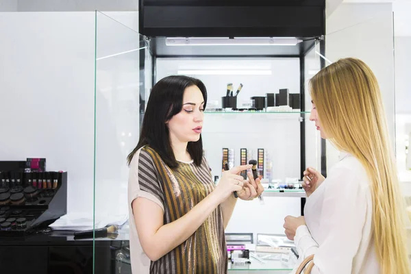 Young pretty woman and beauty consultant in shop — Stock Photo, Image