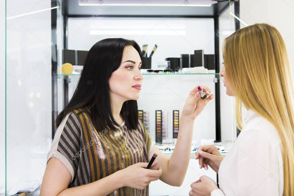 Young pretty woman and beauty consultant in shop