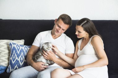 Genç adam hamile kadın ve kapalı kedi