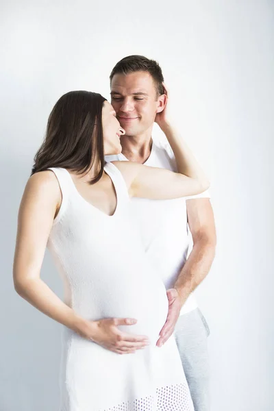 Young man and pretty pregnant woman hugging together — Stock Photo, Image