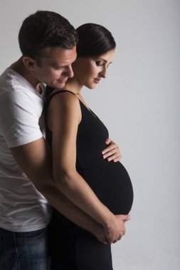 Genç adam ve çok hamile kadın kucaklama
