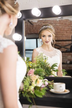 Ayna yakınındaki genç gülümseyen güzel gelin