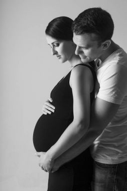 Genç adam ve çok hamile kadın kucaklama