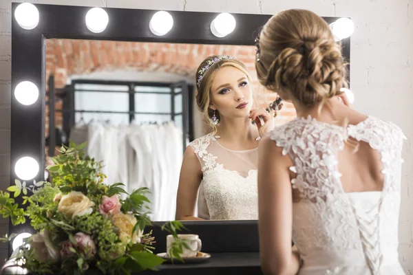 Jonge mooie lachende bruid in de buurt van spiegel — Stockfoto