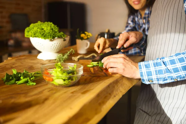 Jovem e mulher cozinhando salada juntos na cozinha — Fotografia de Stock