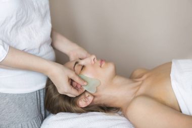 Genç kadın güzellik kliniğinde yüz bakımı görüyor.