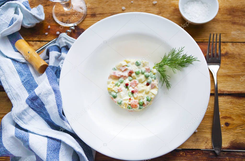 Bowl of traditional russian salad on wooden table