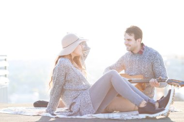 Genç adam ve kadın dışarıda eğleniyor gitar ile