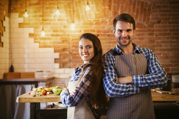 Giovane coppia sorridente cucina insieme — Foto Stock