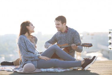Genç adam ve kadın dışarıda eğleniyor gitar ile