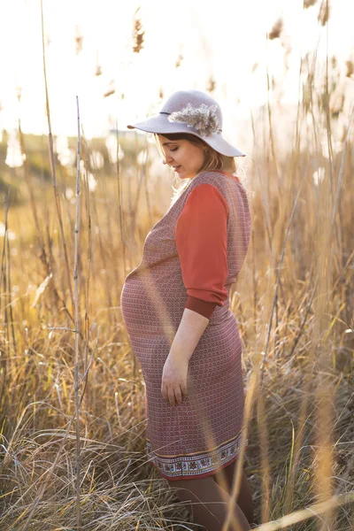 Young pretty pregnant woman outdoors on sunset — Stock Photo, Image