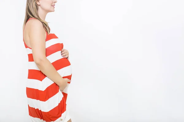 Jonge mooie lachende zwangere vrouw op witte achtergrond — Stockfoto