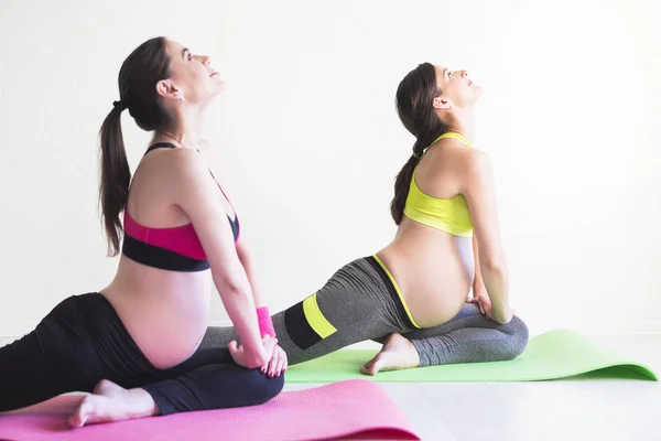 Dos mujeres embarazadas jóvenes haciendo ejercicios de fitness —  Fotos de Stock