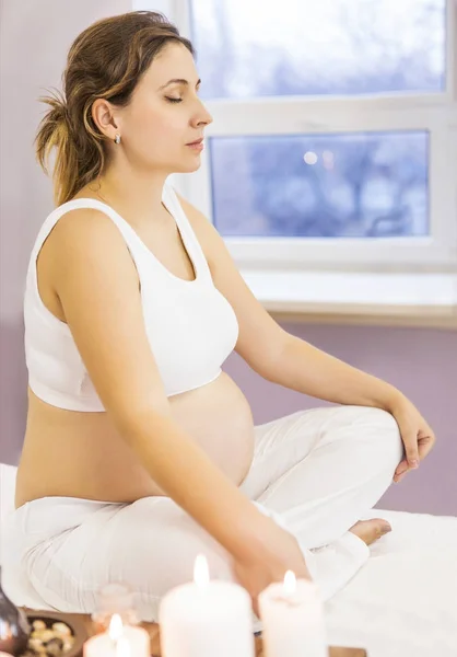 Unga gravid kvinna sitter i en lotus ställning — Stockfoto