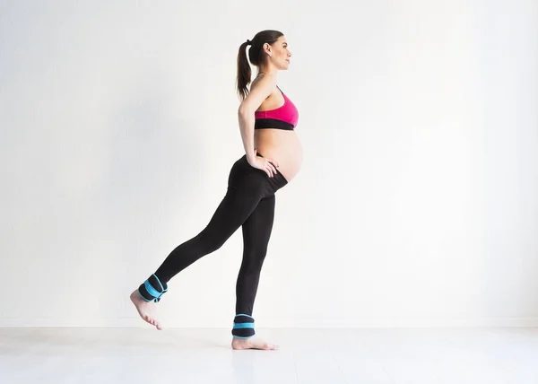 Jedna mladá těhotná žena dělá fitness cvičení — Stock fotografie
