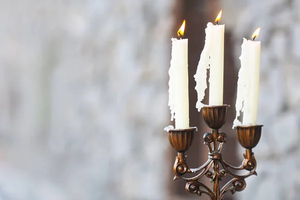 Kandelabr z trzy świece na szarym tle — Zdjęcie stockowe
