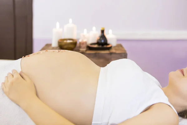 Unga gravid kvinna har massagebehandling på spa — Stockfoto