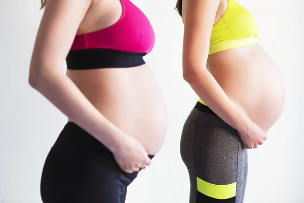 İki genç hamile kadınlar yoga egzersizleri yapıyor — Stok fotoğraf