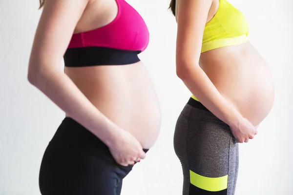 Due giovani donne incinte che fanno esercizi di yoga — Foto Stock