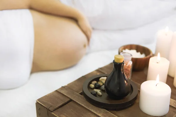 Молодая беременная женщина получает массаж в спа — стоковое фото