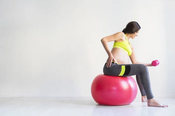 One young pregnant woman doing fitness exercises — Stock Photo, Image