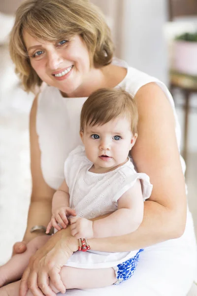 Reife Frau Umarmung mit Baby-Mädchen — Stockfoto