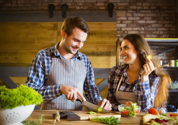 Jeune couple souriant cuisiner ensemble — Photo