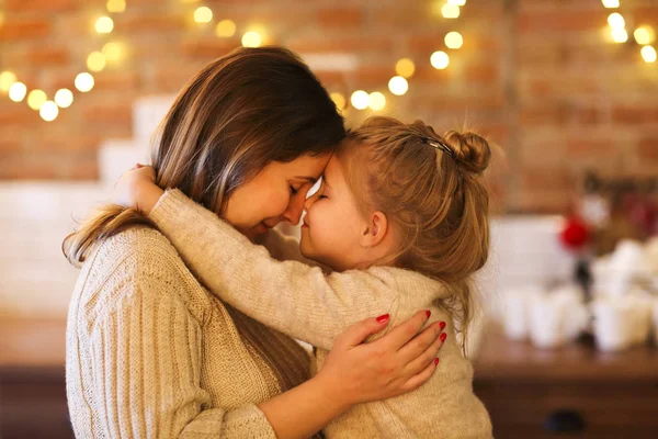 Beautiful woman and her daughter hugging indoors — Stock Photo, Image