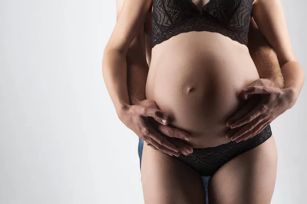 Hombre joven y mujer embarazada en el estudio — Foto de Stock