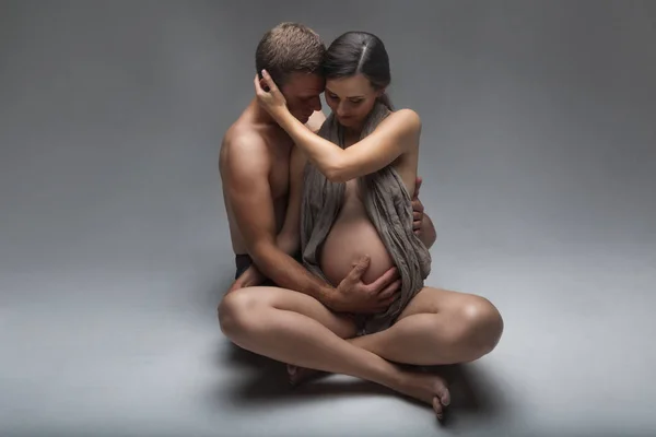 Молодой человек и беременная женщина в студии — стоковое фото