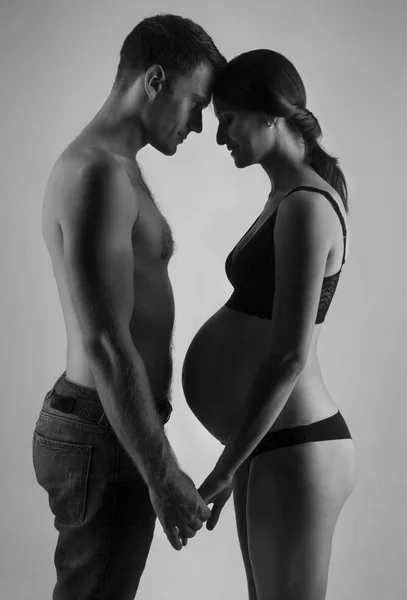Jonge man en zwangere vrouw in studio — Stockfoto