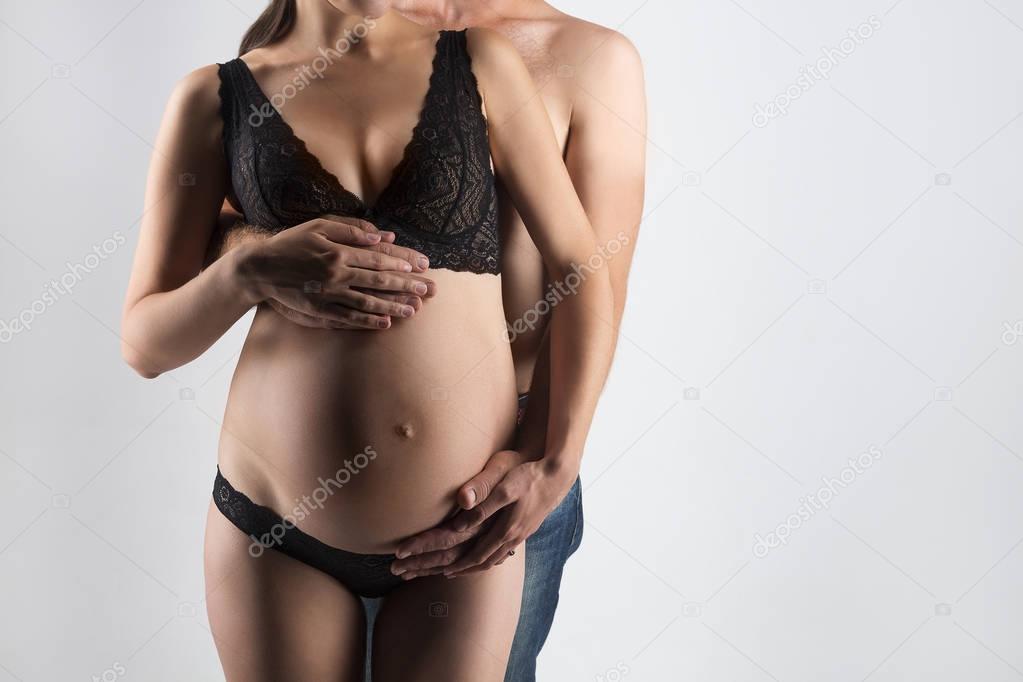 Young man and pregnant woman in studio