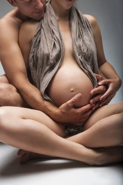 Молодой человек и беременная женщина в студии — стоковое фото