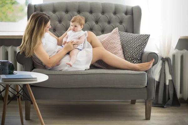 Mooie jonge vrouw en babymeisje binnenshuis — Stockfoto