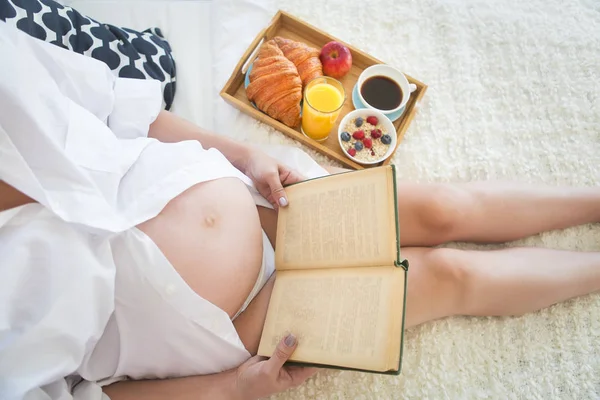 Mujer embarazada desayunando con café, jugo de naranja, crois — Foto de Stock