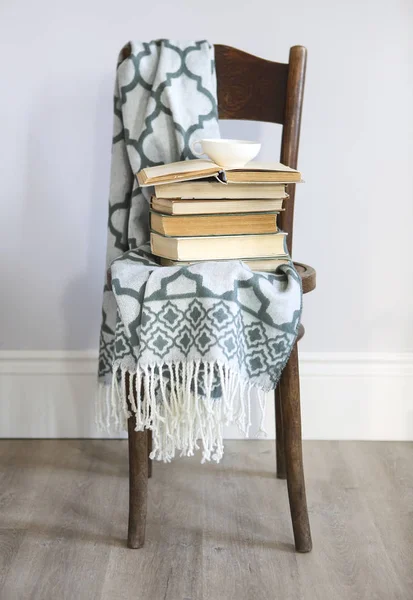 Xícara de café e livros na cadeira de madeira — Fotografia de Stock